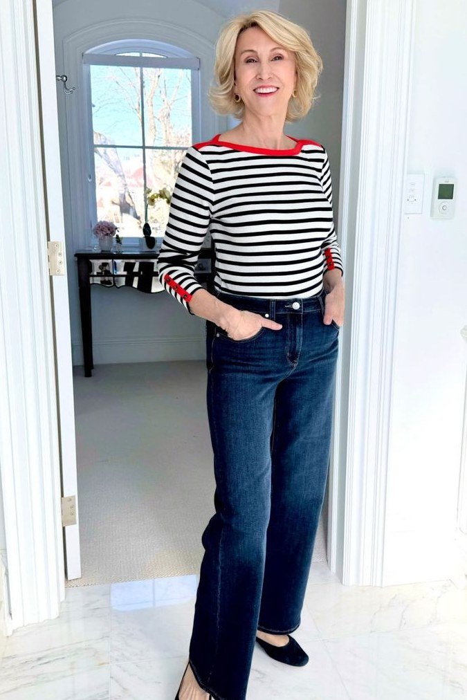 A striped top with red trim and dark jeans is playful Parisian style. The red trim adds a flirty touch to the classic stripe. Blonde hair looks sunny with the nautical feel. Fun for weekend adventures.