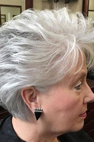 Tousled white-grey pixie, salon setting, smiling grey hairstyle for women over 50