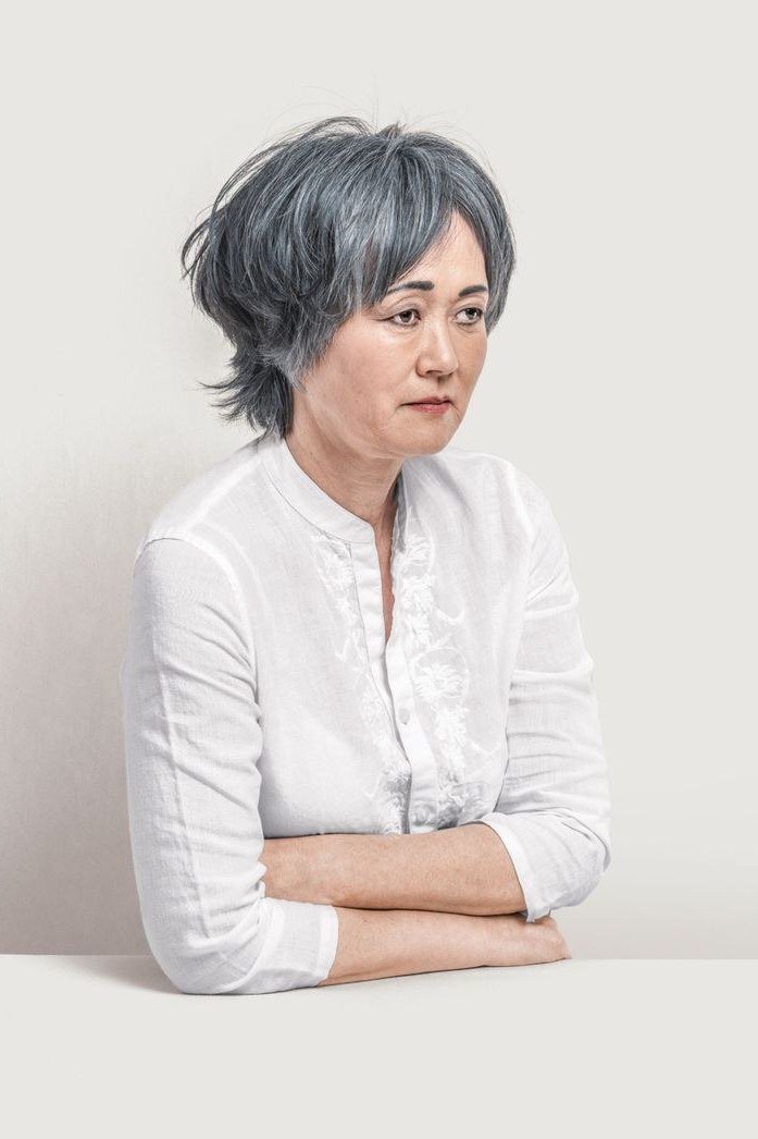 Older asian woman, short grey pixie, white shirt grey hairstyle for women over 50