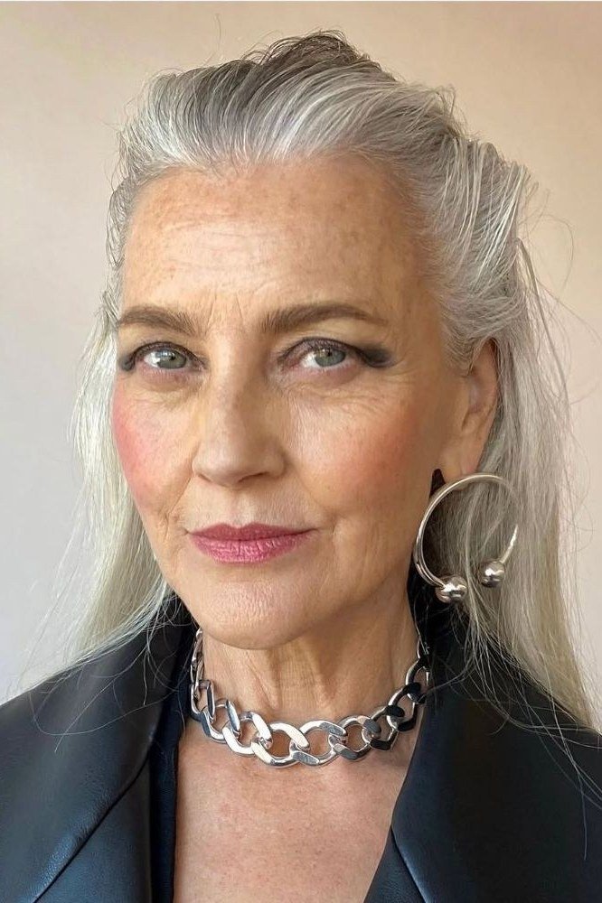 Silver high ponytail, chain necklace, dark jacket grey hairstyle for women over 50