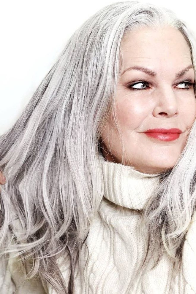 Long silver hair, white turtleneck, smiling grey hairstyle for women over 50