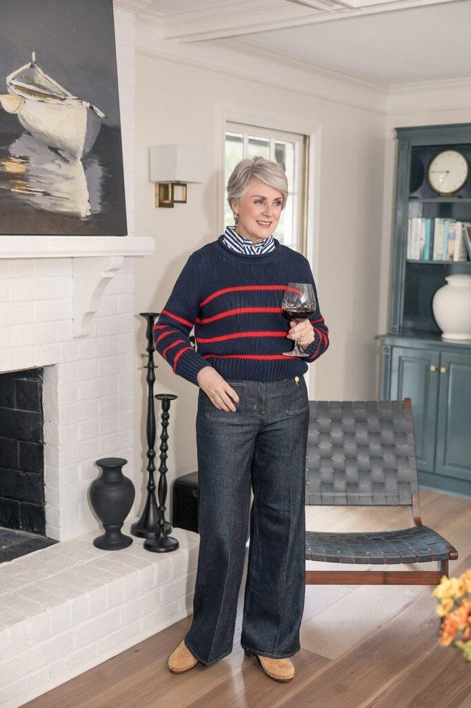 Striped navy sweater with wide-leg dark jeans indoors, polished casual fall outfit for women over 40
