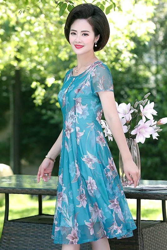 Teal blue floral midi dress in a garden setting, fresh summer style for mature women