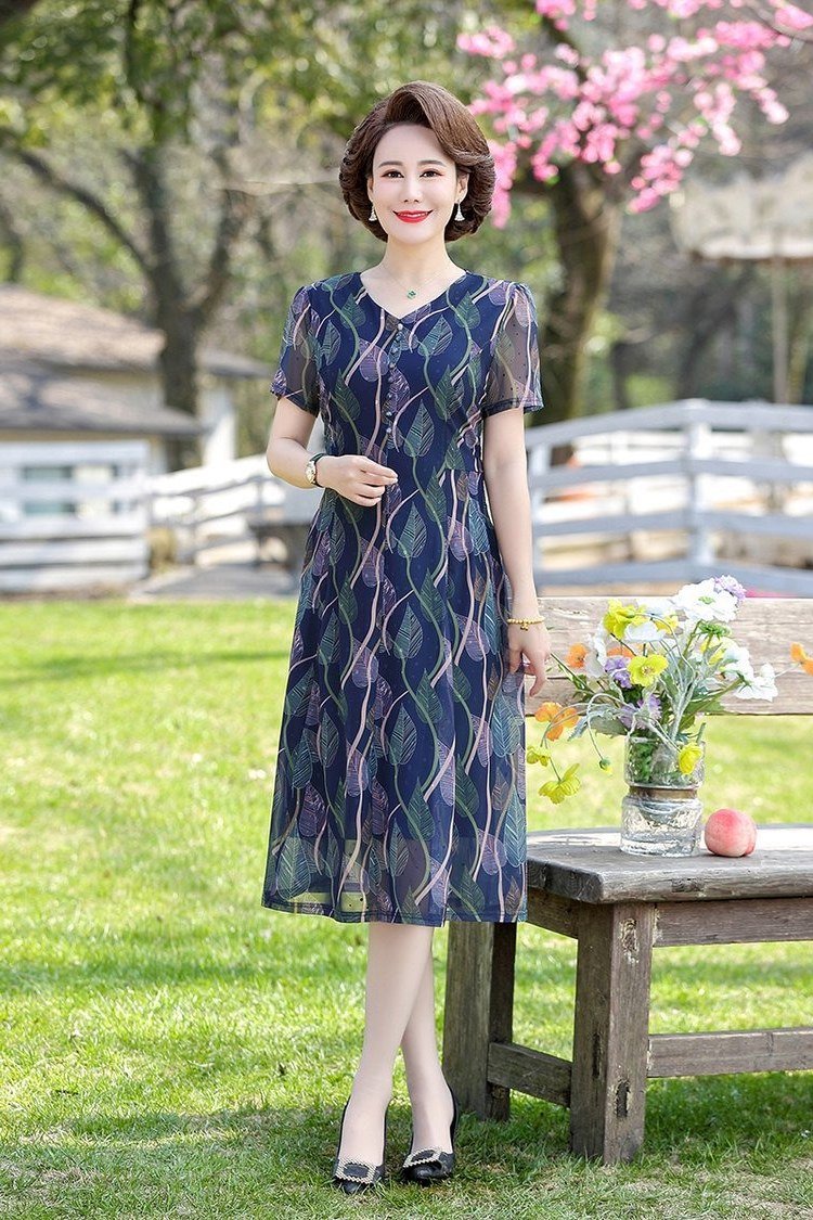 Navy blue patterned midi dress in a garden, classic summer look for women over 60