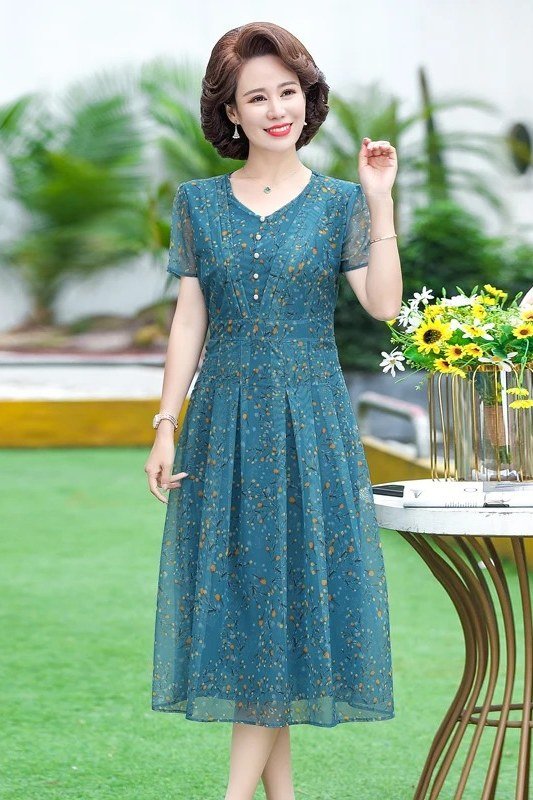 Teal lace midi dress with yellow flowers nearby, romantic summer style for mature women