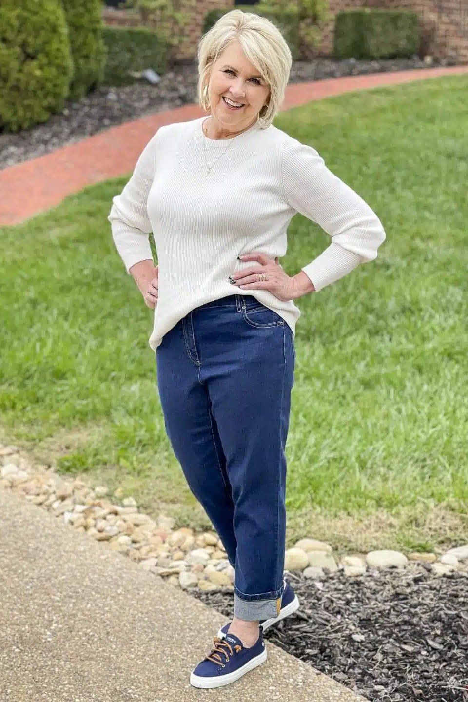 White sweater with navy blue pants outdoors, crisp fall outfit for women over 40