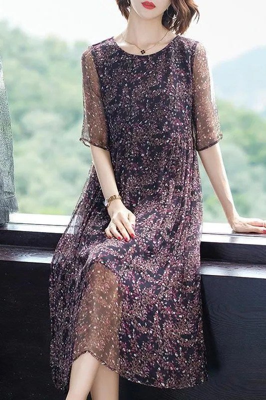 Dark plum floral lace midi dress seated by a window, moody summer elegance for older women