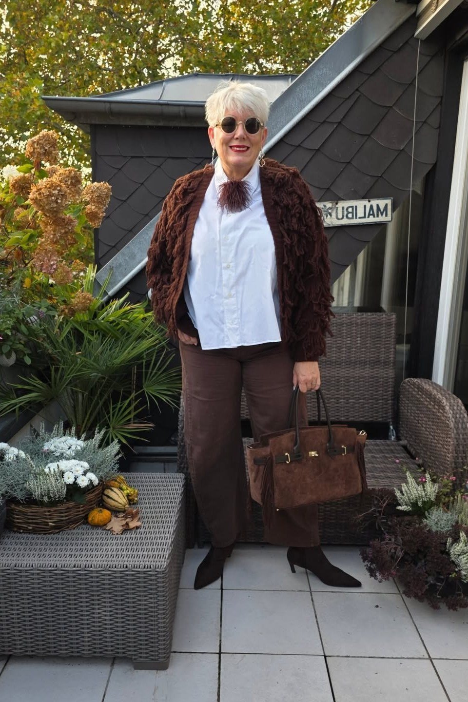 Brown faux fur jacket with white shirt and dark pants, glamorous fall outfit for mature women
