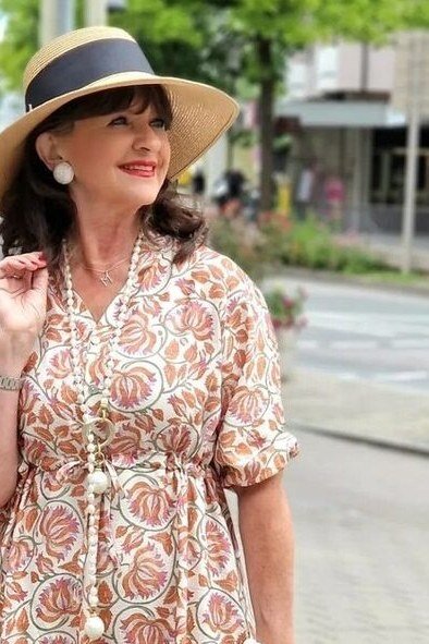 Beige paisley midi dress with a sun hat, bohemian summer look for older women