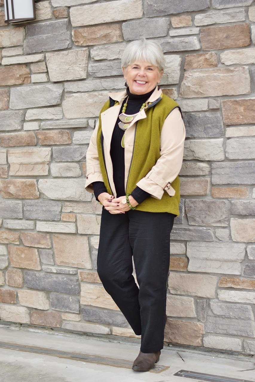 Olive quilted vest with black top and pants, layered fall outfit for mature women