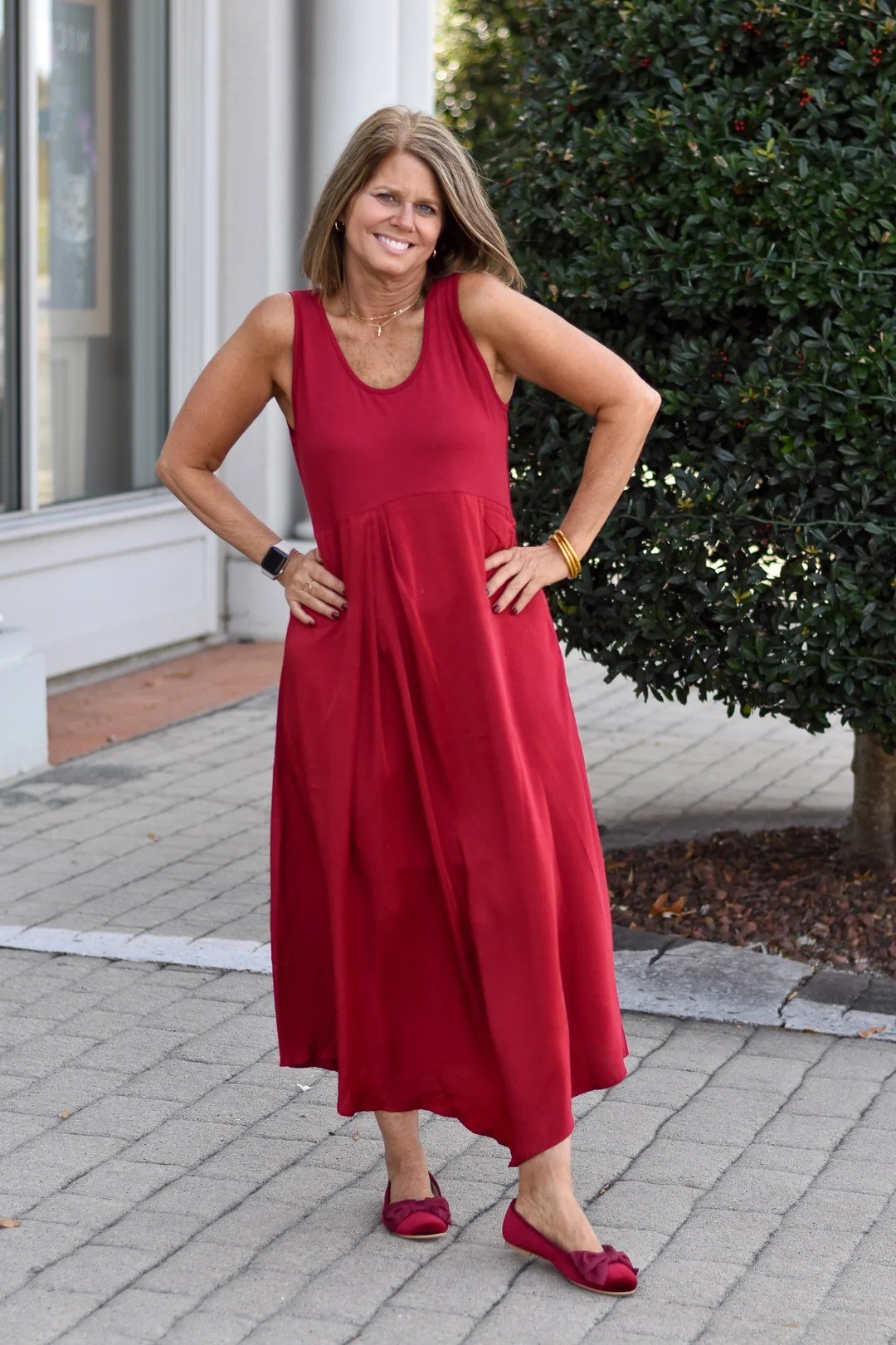 Flattering red sleeveless maxi dress, brick sidewalk for women over 60