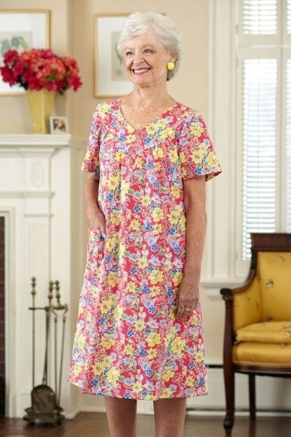 Pink and yellow floral midi dress, silver hair, fireplace room
