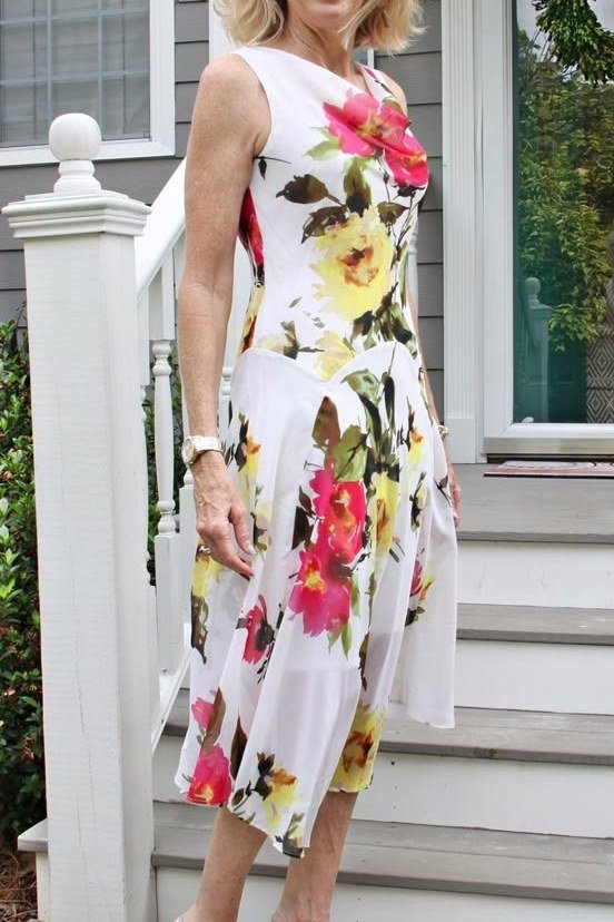 White sleeveless dress with colorful garden floral, porch steps