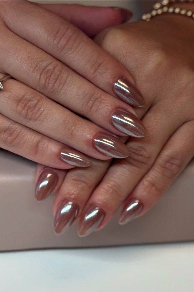 Bronzed cocoa chrome almond nails on dark skin with gold rings