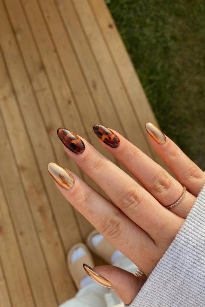 Tortoiseshell accent nails with nude base, almond shape