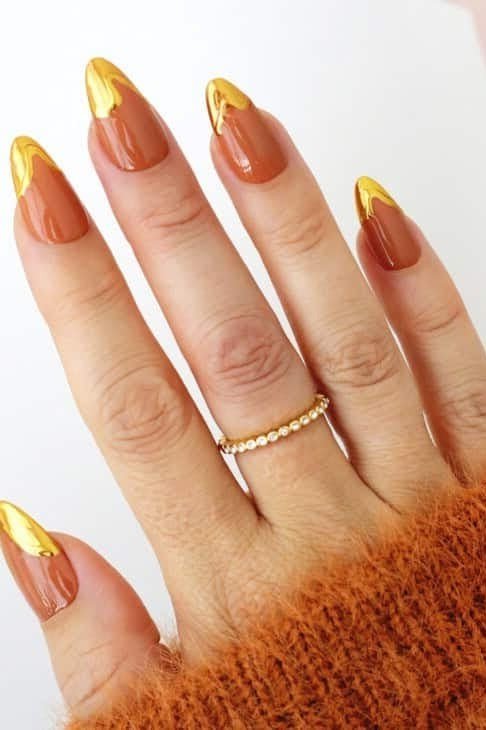 Burnt orange chrome nails with gold chrome tips, orange sweater
