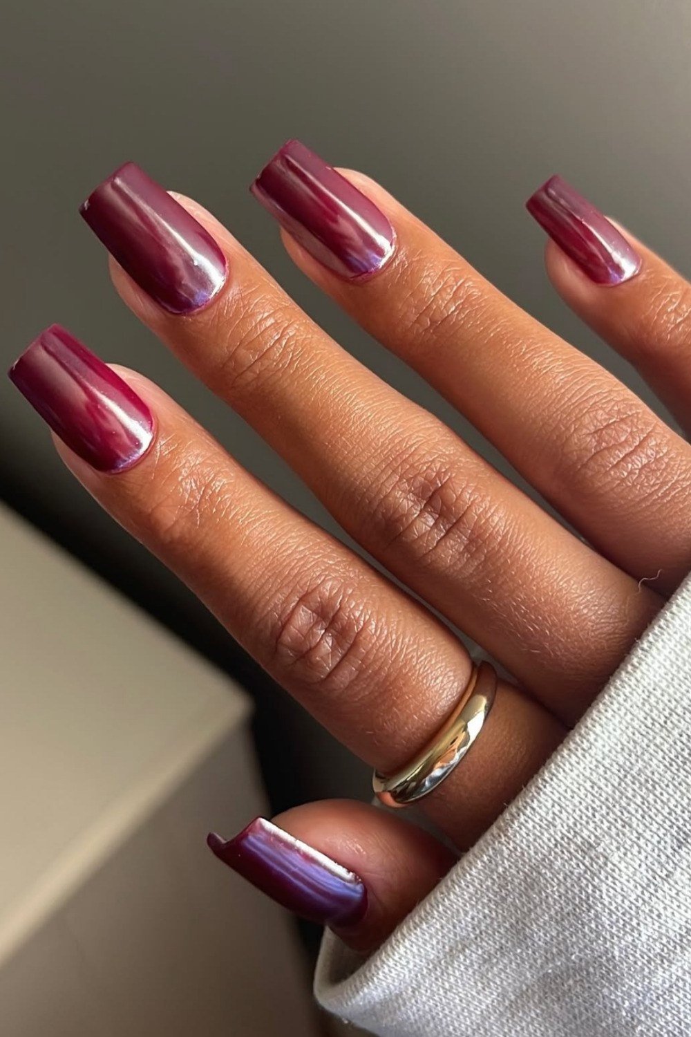 Violet sheen red chrome almond nails with gold ring