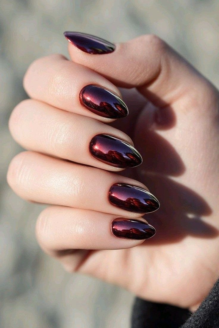 Sunlit cherry chrome almond nails glowing in sunlight