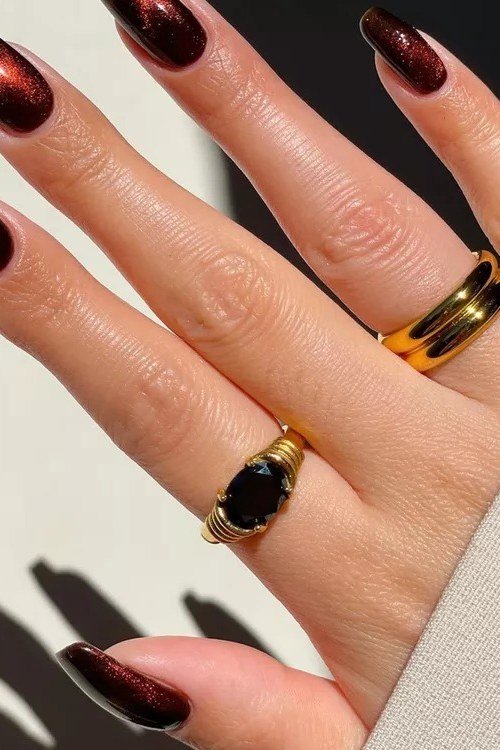 Black-tie cherry deep red chrome almond nails with gold rings
