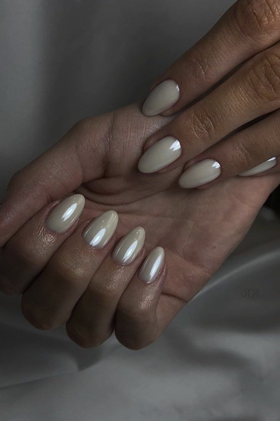 Pearl white chrome almond nails, cupped hands