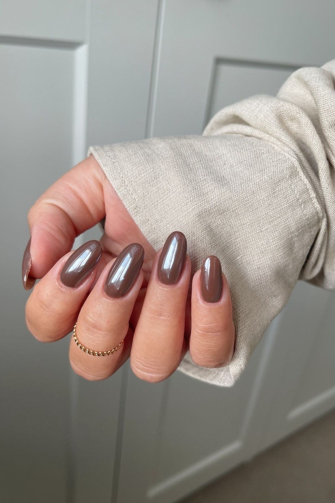 Taupe tranquility grey chrome almond nails, cream sleeve