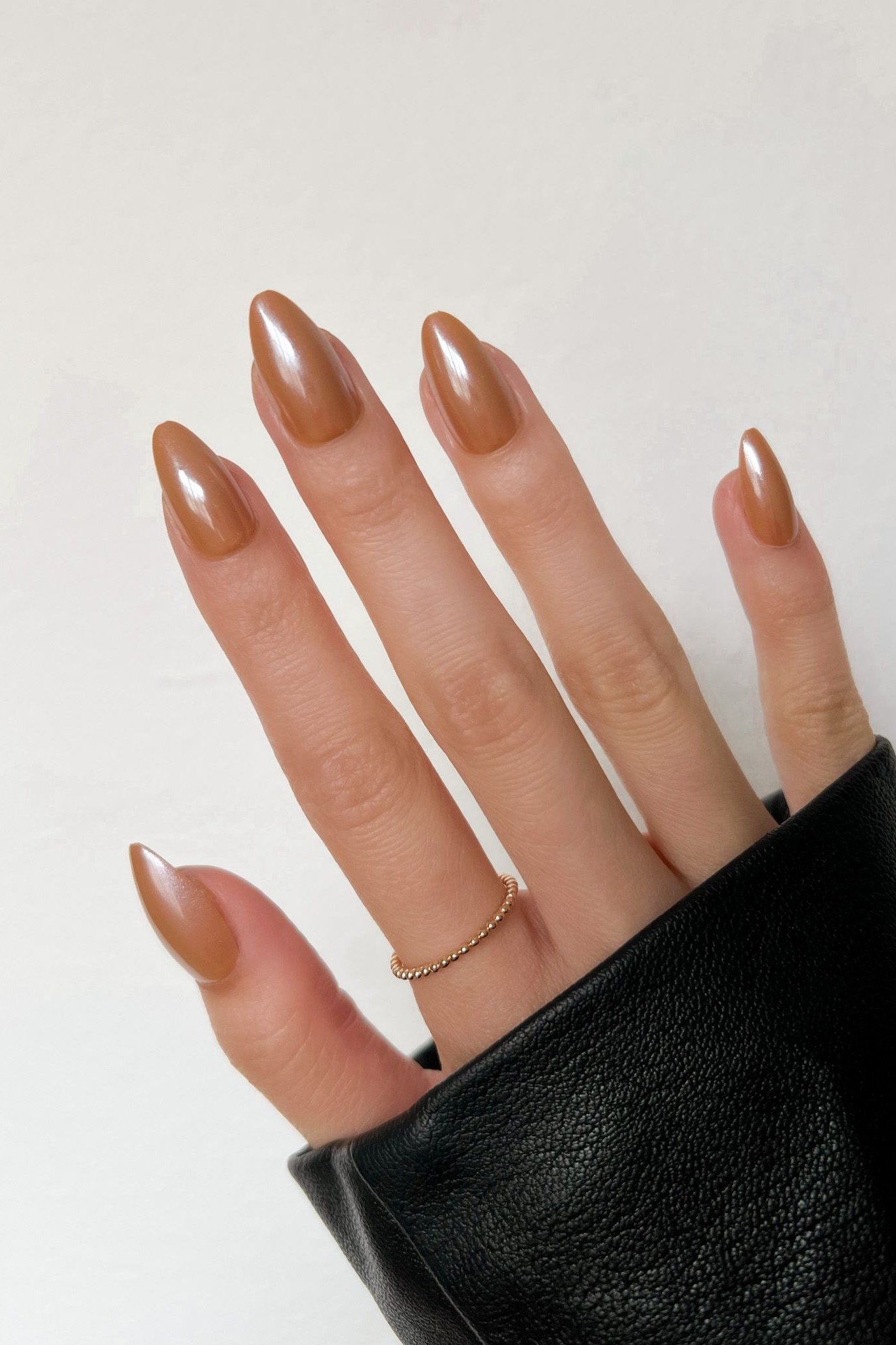 Caramel chrome almond nails with black sleeve