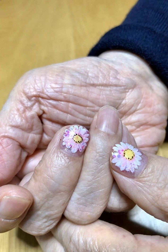 Purple daisy nail art close up for women over 50