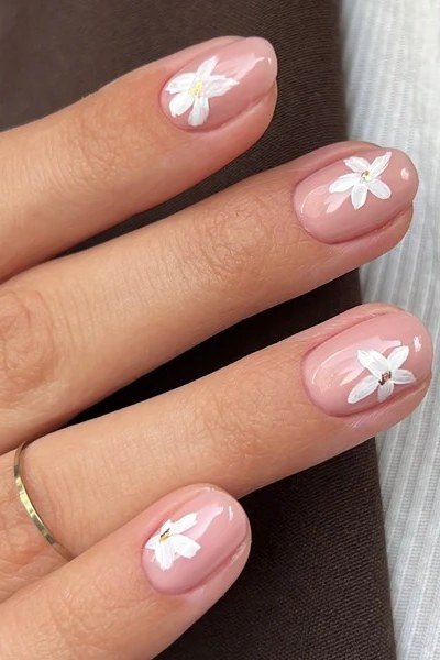 White daisy nail art on bare nude nails for women over 50
