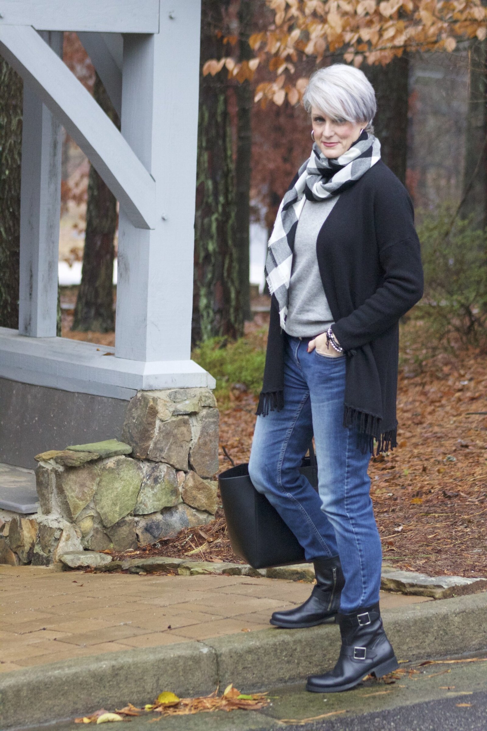 Black wool coat, gray scarf, blue jeans, black ankle boots, older woman on porch