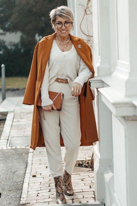 Rust wool coat, cream sweater and wide pants, snakeskin ankle boots