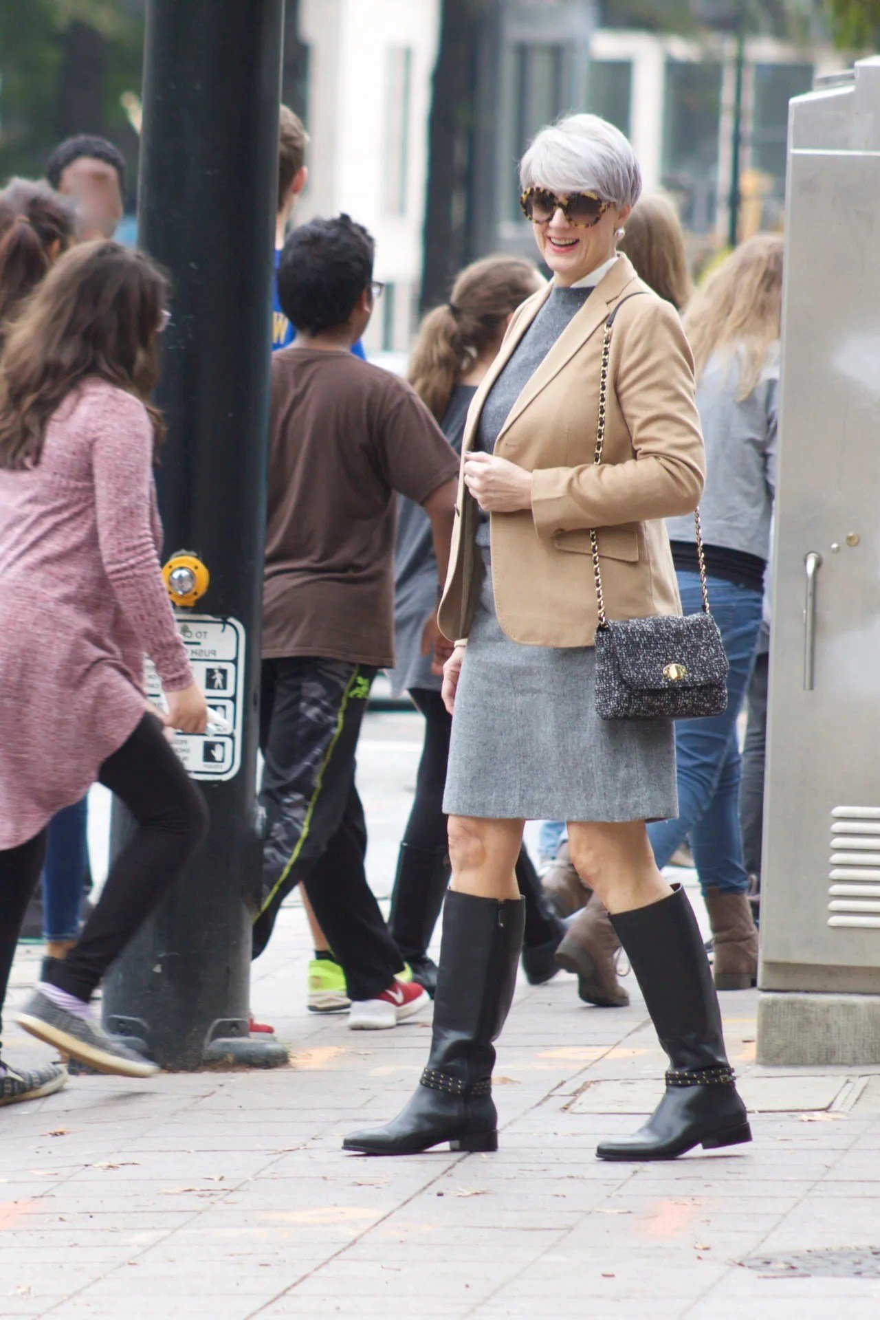 Beige utility jacket, gray pencil skirt, black knee boots, woman on street