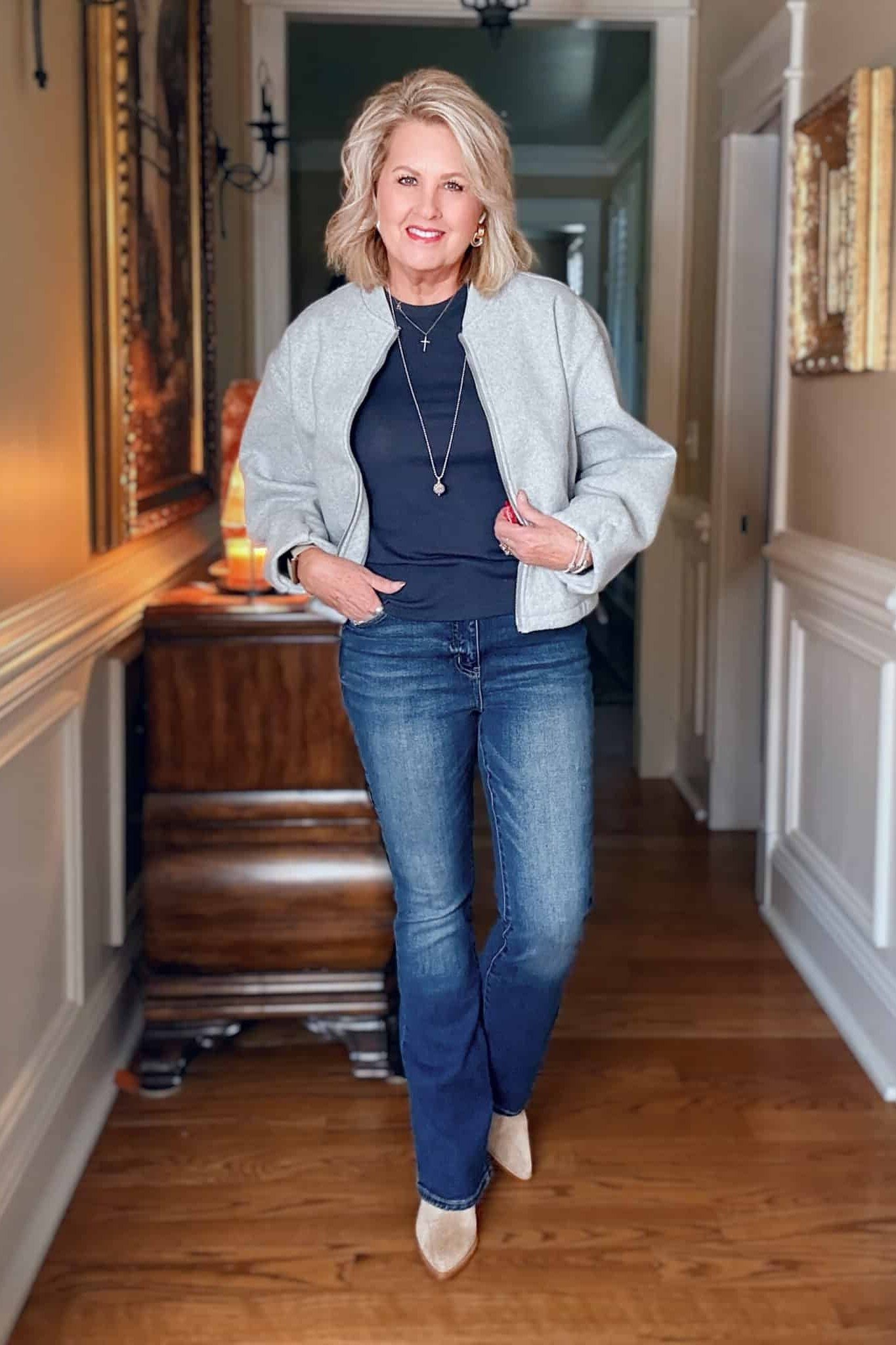 Light-wash denim jacket, navy top, blue jeans, woman in hallway