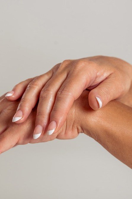 Side view of mature hands with white-tip french nails