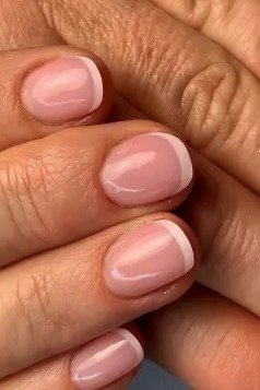 Rose pink french manicure on curled fingers