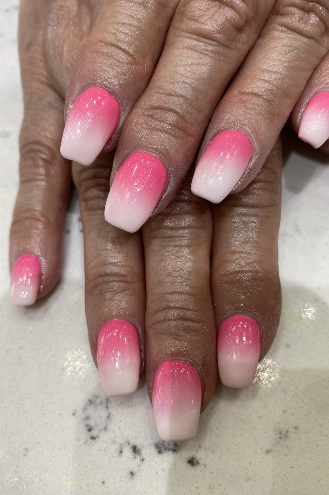Dark-skinned hands with pink gradient french tips