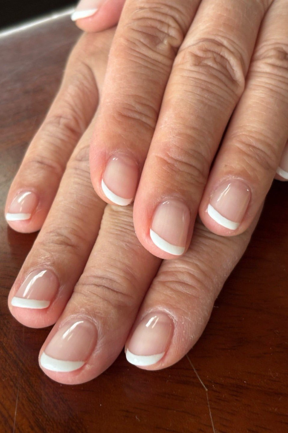 Oval french manicure on tan hands