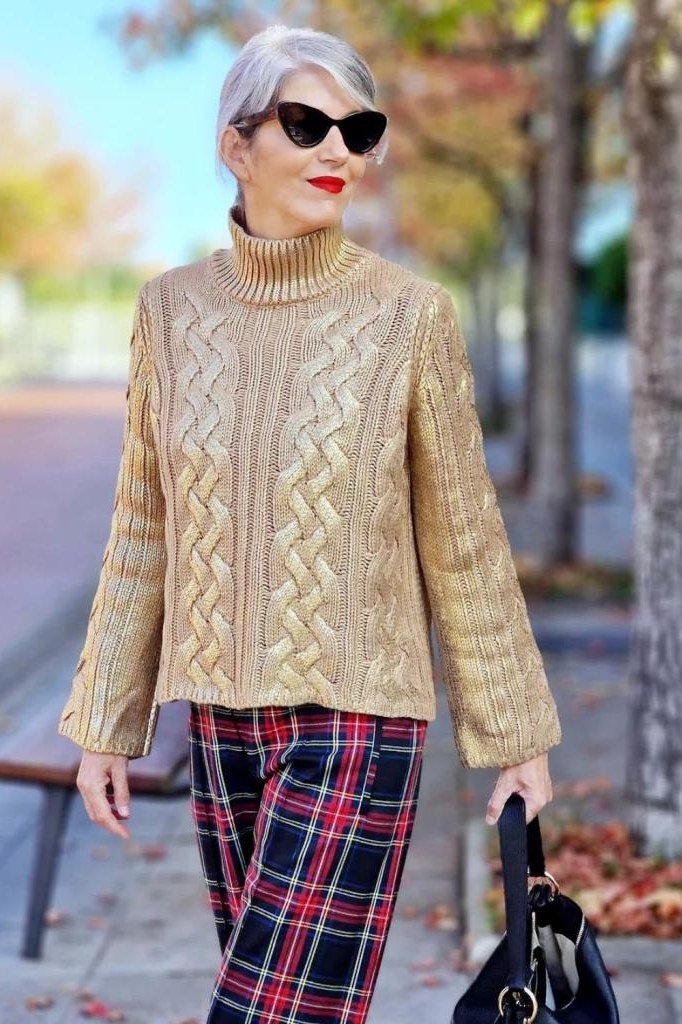 Fall sweater outfit idea 4 for women over 60: camel cable-knit turtleneck with red plaid pants