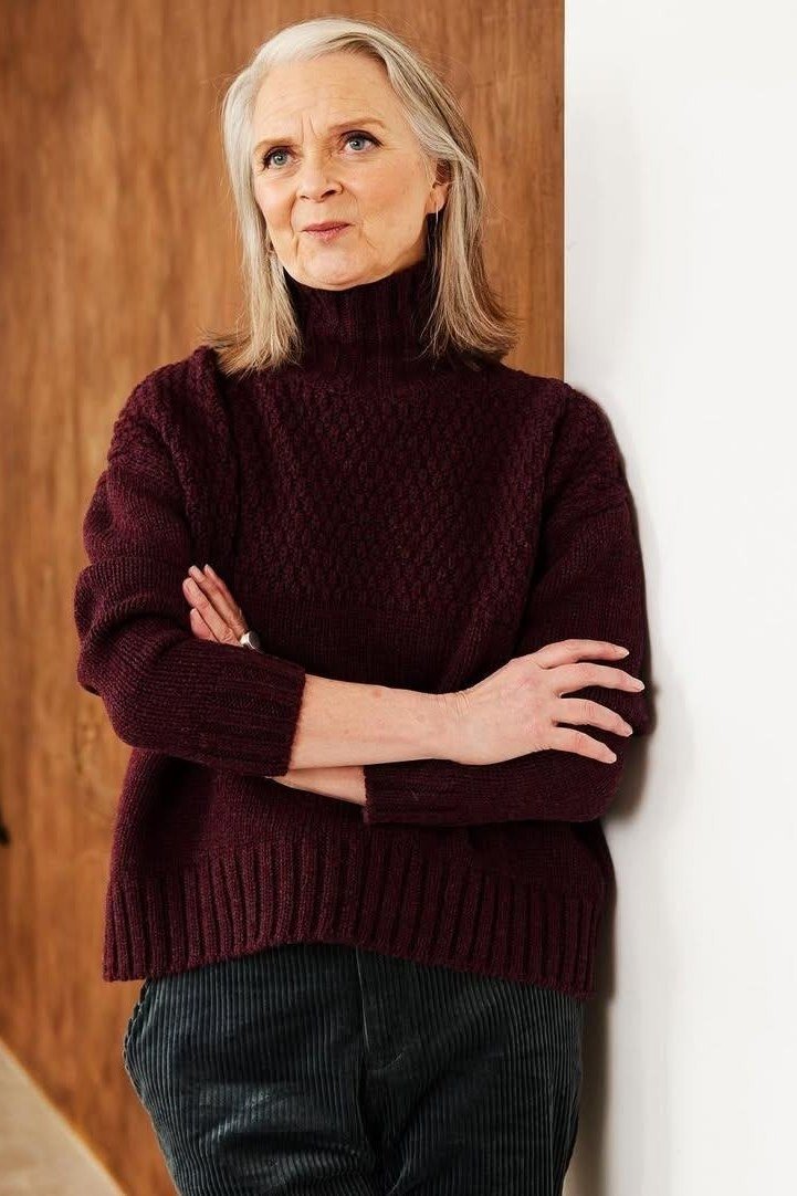 Fall sweater outfit idea 7 for women over 60: burgundy cable-knit turtleneck with dark jeans