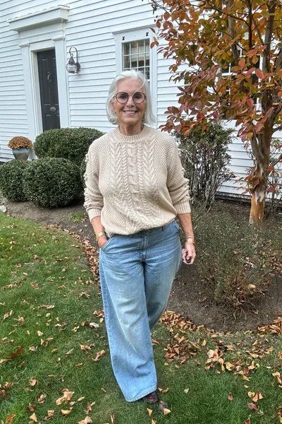 Fall sweater outfit idea 14 for women over 60: cream cable-knit with light wide-leg jeans