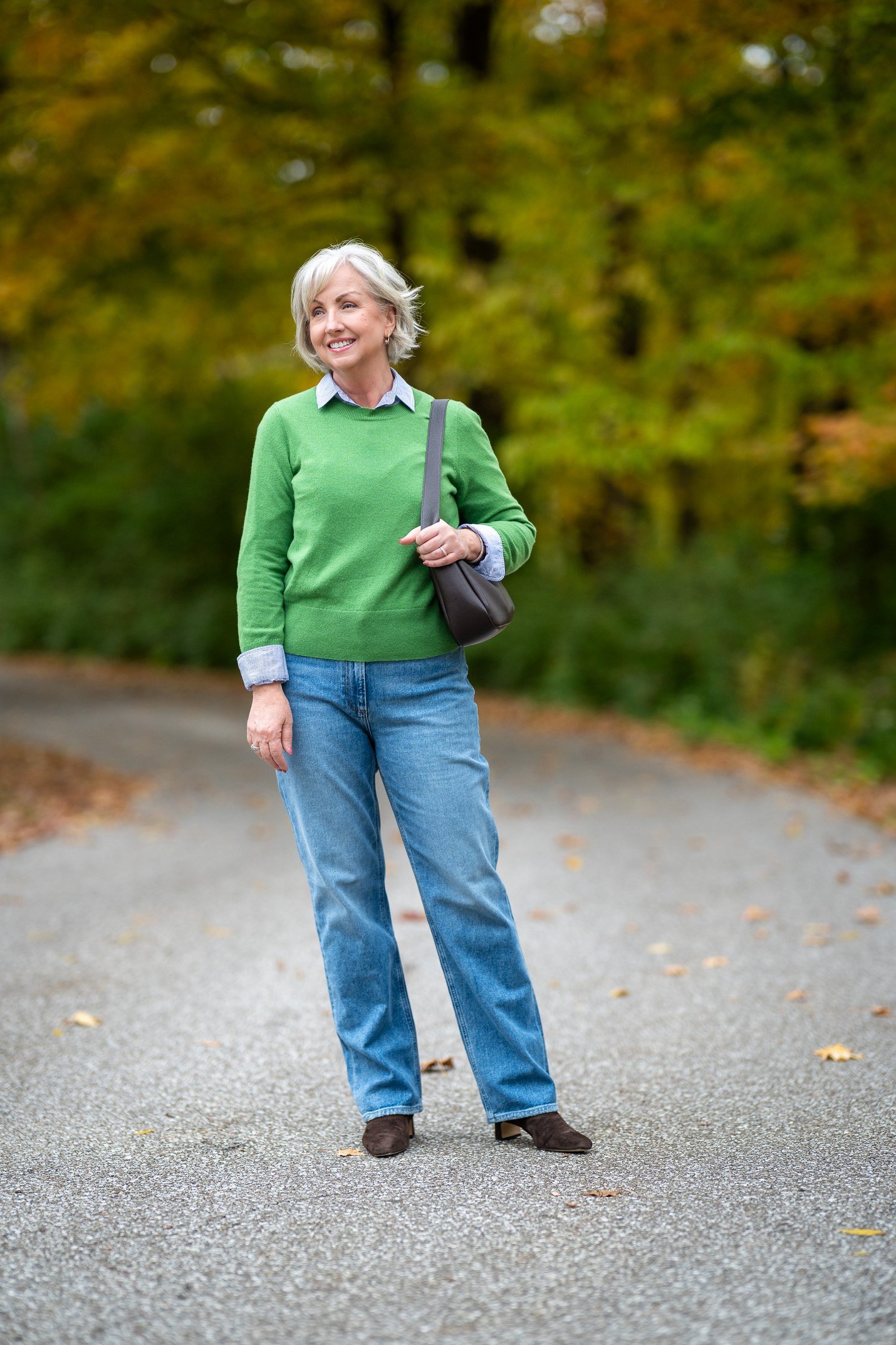 Fall sweater outfit idea 23 for women over 60: green sweater with light blue jeans