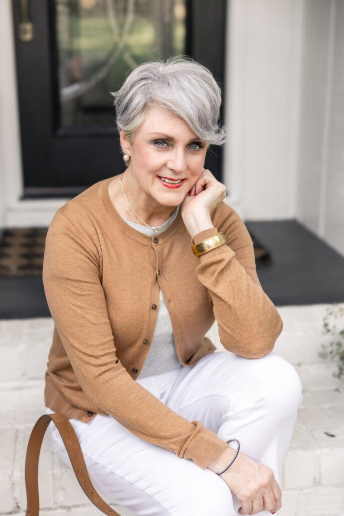 Fall sweater outfit idea 31 for women over 60: camel cardigan with white pants