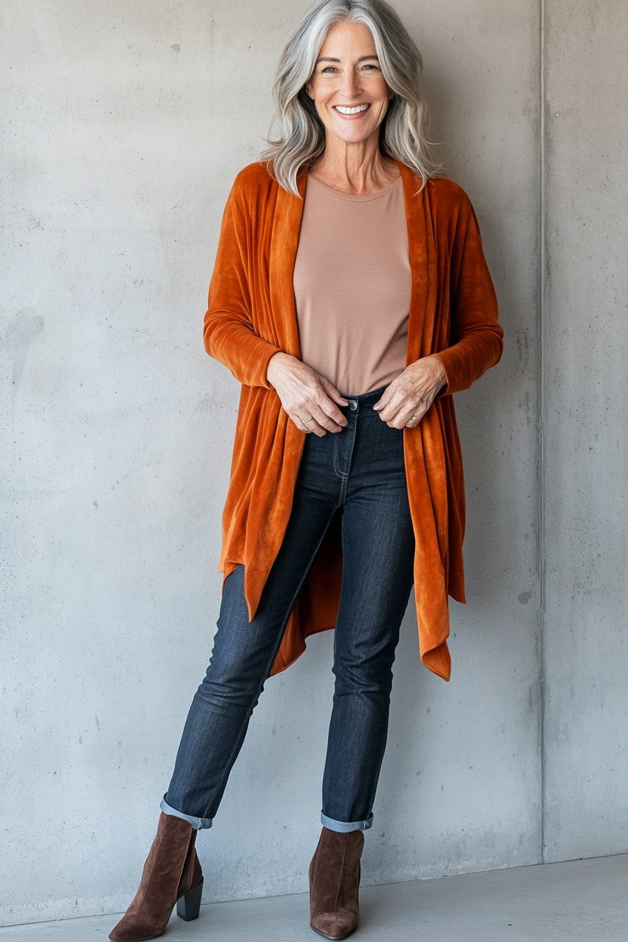 Fall sweater outfit idea 37 for women over 60: burnt orange cardigan with dark jeans and boots