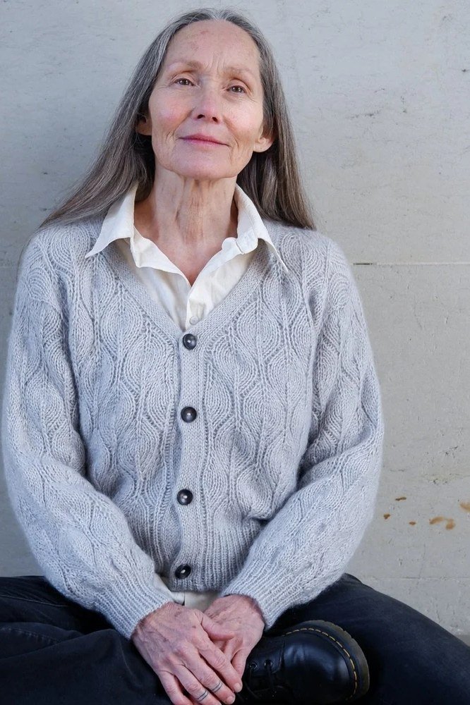 Fall sweater outfit idea 44 for women over 60: gray cable cardigan with white shirt and dark jeans