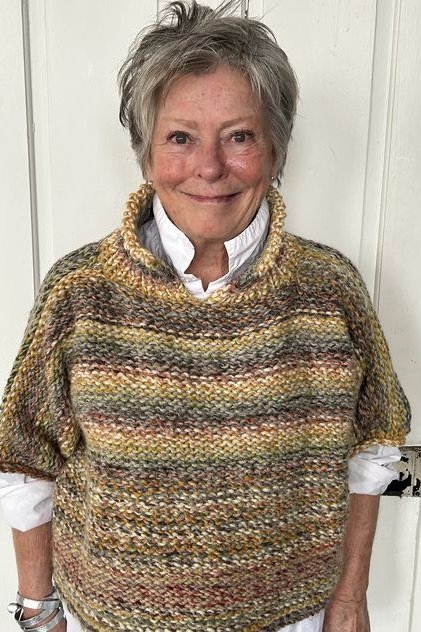 Fall sweater outfit idea 51 for women over 60: multicolor knit poncho with white shirt