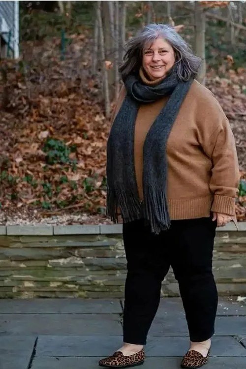Fall sweater outfit idea 63 for women over 60: rust sweater with dark scarf and black pants