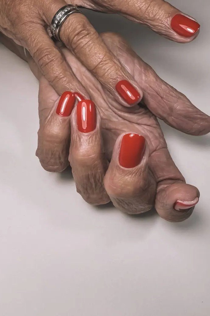 Bright Red Nails on Aged Hands - gel nail design for women over 50