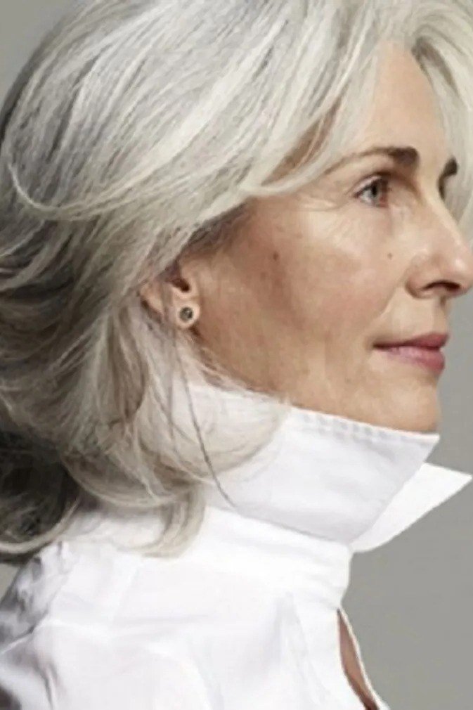Shoulder-length layered silver hair, side profile view of woman in white shirt