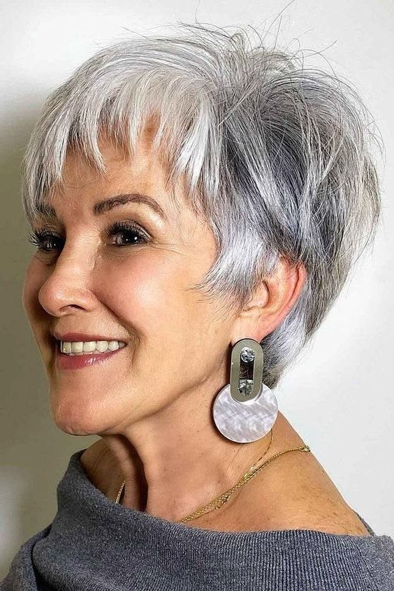 Textured white pixie haircut with soft fringe and statement earrings