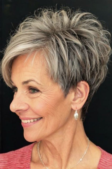 Salt-and-pepper textured pixie haircut, smiling side view of older woman