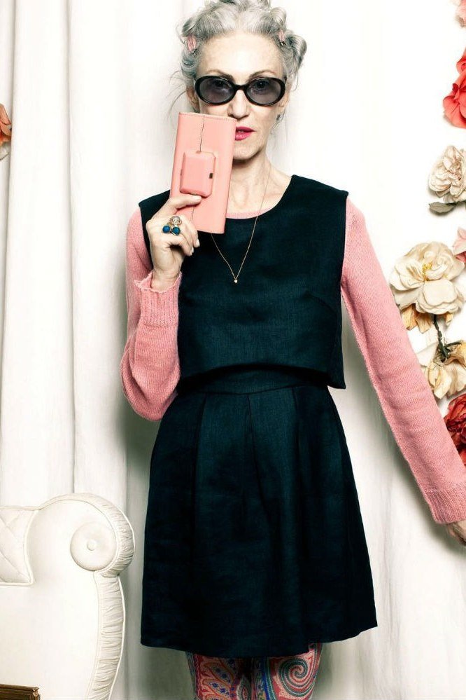 Older woman in black dress with pink sleeves
